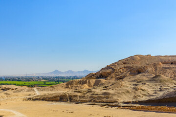 Wall Mural - Archeological site near the temple of Hatshepsut in Luxor, Egypt. Green landscape on a background
