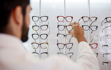 Wall Mural - Man in optic store choosing a new glasses. Medical, health care concept