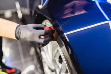 Wall Mural - A man cleaning car, car detailing (or valeting) concept. Selective focus..