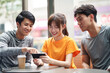 © imtmphoto - three young asian adults looking at cellphone