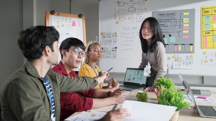 Asian female creative designers present ux ui to team.Designers team working meeting in a modern office.