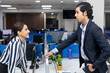 © Bhaven - Portrait of two young Indian businesspeople discussing project across workstation, corporate environment.