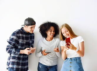 Wall Mural - Happy friends using smartphone together social media concept