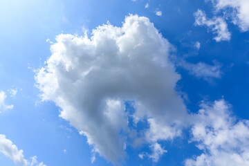 Strangely shaped white clouds on the blue sky.