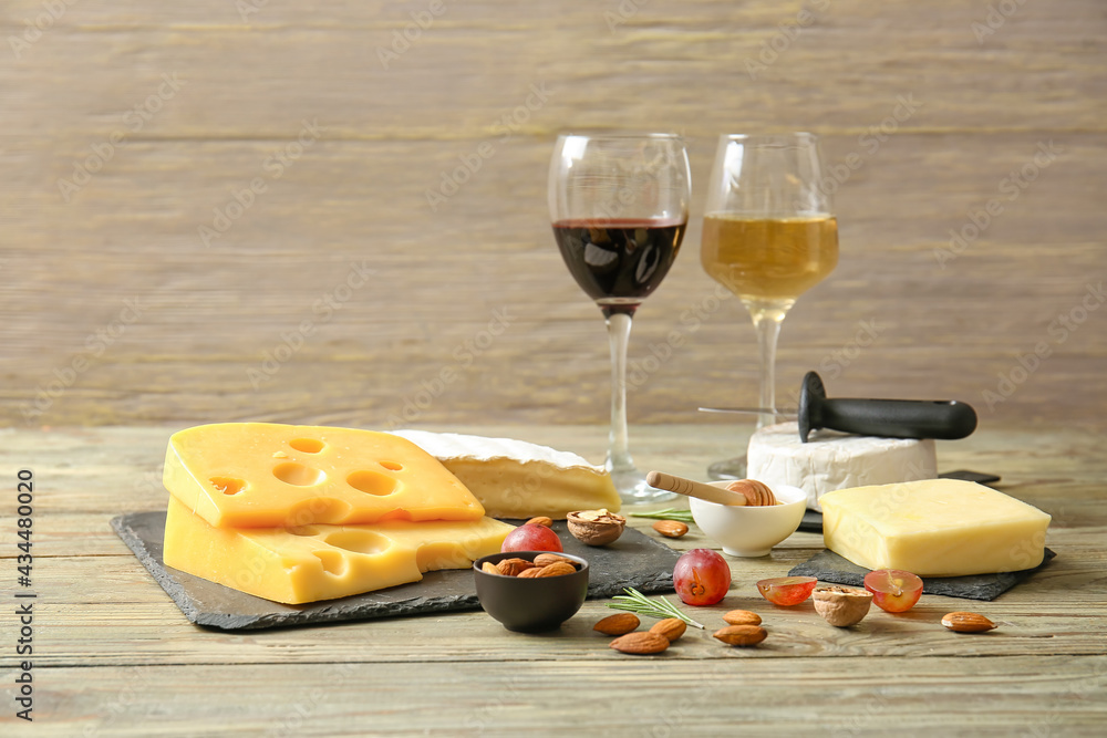 Composition with tasty cheese, wine, nuts and grapes on wooden background