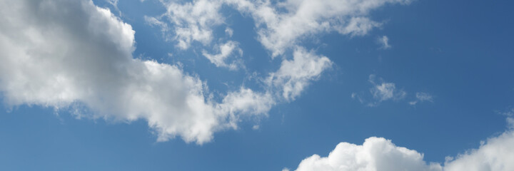 blue sky with white clouds backlit by sunlight