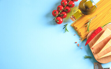 Wall Mural - Uncooked pasta on blue background. Top view. Raw pasta with ingredients for cooking. Food concept. Italian food