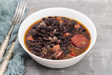 Sticker - black beans with meat and sausages in white bowl