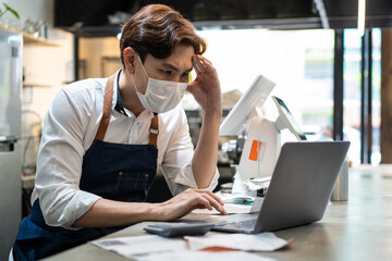 Asian male cafe owner getting business crisis from effect of COVID-19.