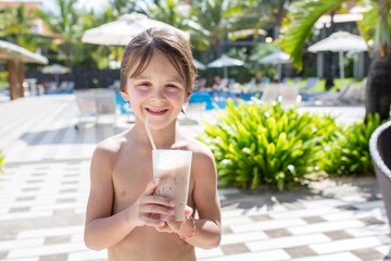 Poster - Cute boy, drinking choco milkshake on the pool deck while on holiday