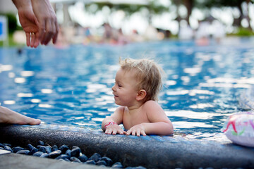 Sticker - Adorable happy little child, toddler boy, having fun relaxing and playing in a pool on sunny day during summer vacation