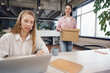 © fotofabrika - Young businesswoman holding box of personal belongings about to leave office after quitting job