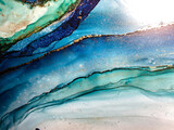 Abstract blue with green background. Beautiful pleats and stains made with alcohol ink and gold pigment. Turquoise and aqua colored fragment with fluid texture resembles watercolor or aquarelle.