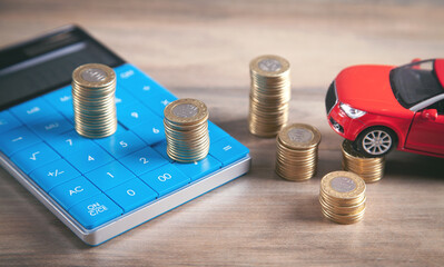 Car, coins, calculator on the desk.