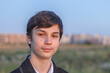 © justoomm - School teenager waiting for a school bus, on his way to school. On the way home from school against the background of the urban landscape