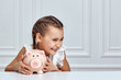 © producer - Little child girl with piggy bank at home