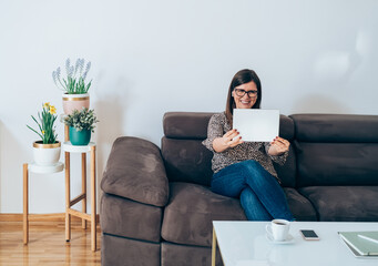 Wall Mural - Businesswoman Making Video conference Meeting with Colleagues During the Coronavirus Shutdown.
Business woman talking with coworkers or clients with wireless earphones on video call on digital tablet.