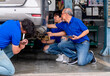 © narong - Head and garage workers help to fix the problem of car in workplace area. Industrial business and management system support employee work concept.