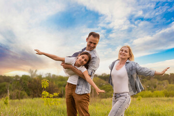 Wall Mural - Young happy family in a field