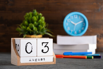 August 03rd. August 03 wooden cube calendar with blur objects on background.