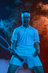 Wall Mural - Happy tennis player celebrating victory. Tennis athlete with racket in white t-shirt. Man playing on dark background with color smoke.