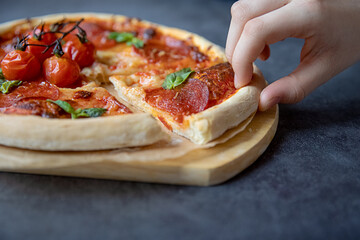 Concept food. Beautiful epperoni pizza with tomatoes on a dark background.