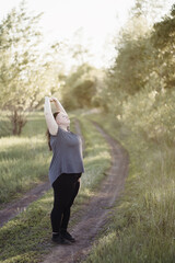 Wall Mural - Young overweight woman doing yoga at summer meadow