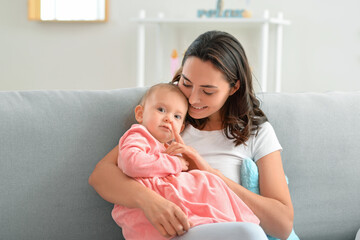 Canvas Print - Happy woman and her little daughter sitting on sofa at home