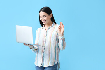 Poster - Beautiful young woman with laptop on color background