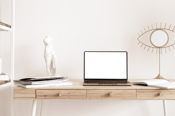 Laptop with blank screen mock-up on wooden table in home scandi interior. Interior still life concept. Stylish minimal working place, copy space