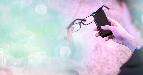 Poster - Composition of light circles over senior caucasian woman holding glasses and smartphone