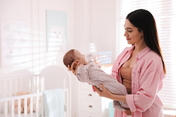 Poster - Young woman with her cute baby at home, space for text