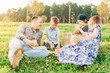 © Anna - Family with two brothers, mother and father summer picnic in nature. Little children with parents hold glasses with cold lemonade in their hands. Kids boys drinking a refreshing drink from the straw.