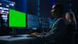 © Gorodenkoff - Confident Male Data Scientist Works on Green Chroma Key Screen Computer in Big Infrastructure Control Room. Specialists Use Computers Showing Graphs, Information. Control Room Professional Team