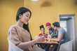 © zinkevych - Cute asian girl having coffee with colleagues and texting