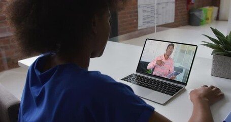 Canvas Print - African american woman talking on video call with male colleague on laptop at office