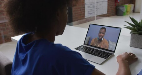 Canvas Print - African american woman talking on video call with male colleague on laptop at office