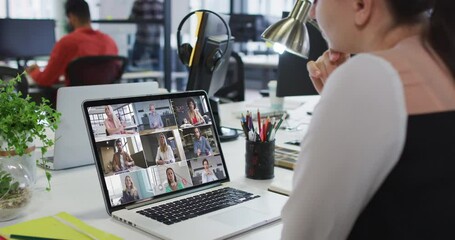 Sticker - Caucasian woman having a video conference with office colleagues on laptop at office