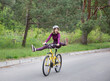 © Anna - funny portrait of an emotional girl in a helmet on a bicycle in motion. having fun riding a bike with his feet off the pedals. healthy active lifestyle. outdoor cycling