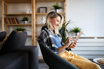 Happy young woman using tablet pc in loft apartment