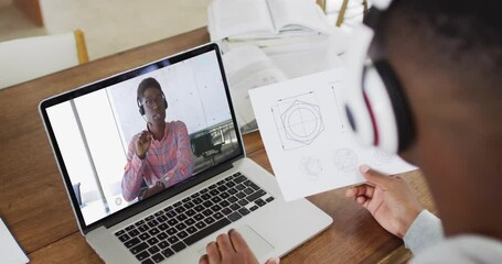 Poster - African american male college student holding notes while having a video call on laptop at home