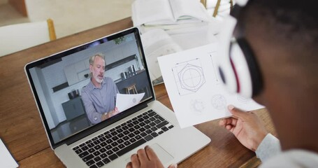 Poster - African american male college student holding notes while having a video call on laptop at home