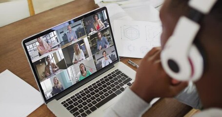 Sticker - African american male college student wearing headphones having a video conference on laptop at home