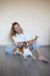 © Aleksandra Iarosh - a young woman combing a beagle dog with a furminator. grooming at home
