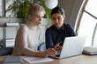 © fizkes - Serious young multiethnic female colleagues employees sit at desk in office work together on computer. Pensive multiracial businesswomen brainstorm on laptop, discuss ideas. Teamwork concept.