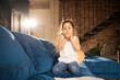 © Yakobchuk Olena - Girl sitting at the sofa and blowing greeting balloons for her mother