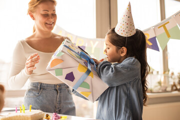 birthday girl examines a box with a gift that her mother gave to her