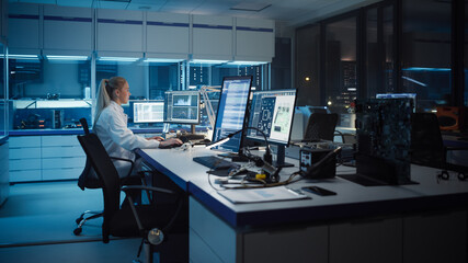 Wall Mural - Modern Electronics Development Facility: Female Engineer Works alone on Computer with Robotics Programming Software. Scientists Design of Industrial PCB, New Generation Silicon Microchips