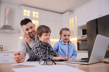 Happy man combining parenting and work at home