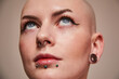 Masculine bald woman with piercing at her face